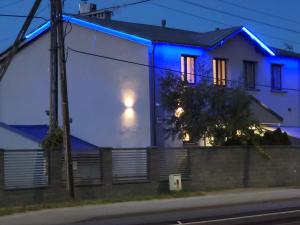 une maison avec des lumières bleues sur son côté dans l'établissement Virgo B&B Biznes Rumia, à Rumia