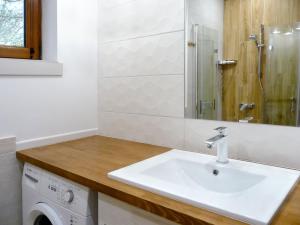 a bathroom with a sink and a washing machine at Domek w Sosnowym Lesie in Sulicice +20 photos