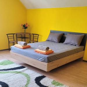 a bedroom with a large bed with a yellow wall at Like Home Hostel in Tiraspol