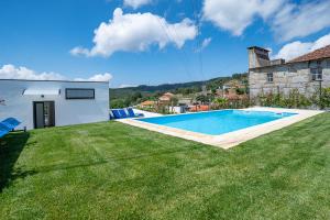 a backyard with a swimming pool and a house at Casa Alto da Massada in Canelas