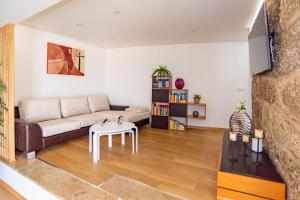 uma sala de estar com um sofá e uma mesa em Casa Alto da Massada em Canelas