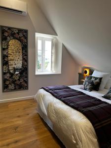 Un dormitorio con una cama grande y una ventana en Les Deux Marguerite, en Alençon