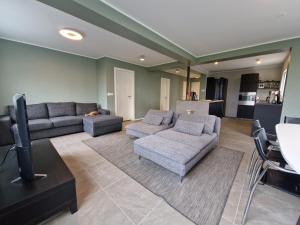 a living room with two couches and a tv at Sólgarður Guesthouse in Bíldudalur