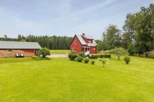 un granero rojo en un campo con un patio verde en Schwedische Landidylle für die ganze Familie, 