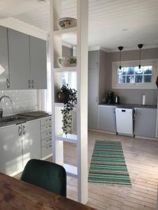 una cocina con armarios blancos y una mesa con una silla verde en Schwedische Landidylle für die ganze Familie, 