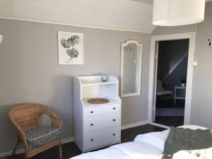 a bedroom with a bed and a dresser and a chair at Schwedische Landidylle für die ganze Familie in Dingelvik
