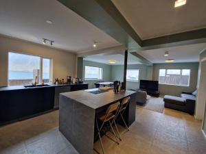 a large kitchen and living room with a large island at Sólgarður Guesthouse in Bíldudalur