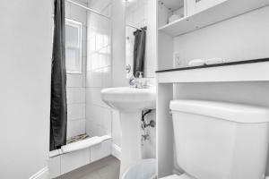 a white bathroom with a sink and a toilet at Laguna Blu Beach in Hollywood