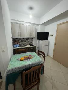 una cucina con tavolo e una cucina con tavolo e sedie di Ylli Mance Apartments a Ksamil