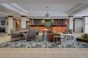 a lobby with chairs and a table and a kitchen at Fairfield Inn & Suites by Marriott Lawton in Lawton
