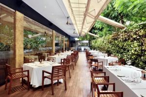 a dining room with white tables and chairs at Marriott Suites Pune in Pune