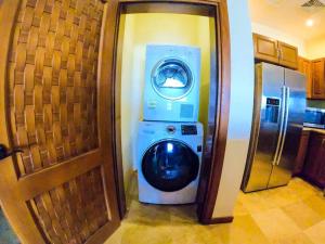 uma máquina de lavar e secar roupa numa cozinha ao lado de uma porta em Relax Enjoy Upscale Villa Pristine Bay em Roatan
