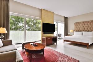 a living room with a bed and a tv at Marriott Suites Pune in Pune