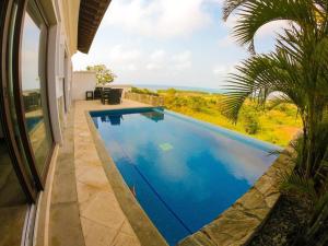 a swimming pool in front of a house at Relax Enjoy Upscale Villa Pristine Bay in Roatan