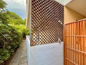 a wooden gate with a wall with a fence at Beach house with private garden and parking in Grado-Pineta