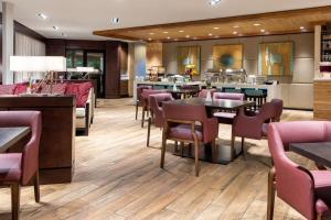 a restaurant with wooden floors and tables and chairs at Sheraton Atlanta Perimeter North in Atlanta
