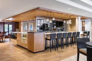 uma cozinha com um bar com bancos de bar pretos em Sheraton Atlanta Perimeter North em Atlanta