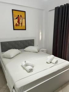 un letto bianco con due asciugamani sopra di Ylli Mance Apartments a Ksamil