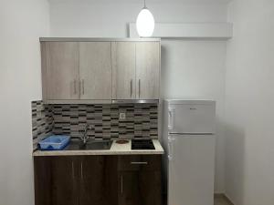 una cucina con lavandino e frigorifero di Ylli Mance Apartments a Ksamil