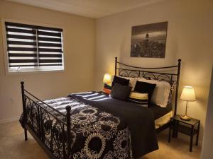 a bedroom with a black bed with pillows and a window at A home away from home in Niagara Falls