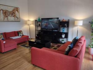 a living room with two red couches and a tv at A home away from home in Niagara Falls