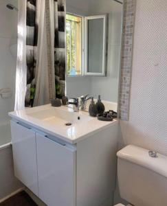 a white bathroom with a sink and a toilet at Studio 27 m2 avec terrasse 20m2 in Six-Fours-les-Plages