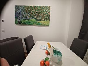 uma mesa branca com um vaso e fruta sobre ela em Alice's dream - Downtown Brescia em Brescia