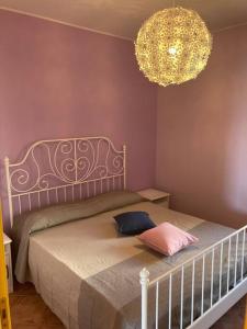 um quarto com uma cama e um lustre em Casa di Ro - coloratissima a 300 metri dal mare em San Bartolomeo al Mare