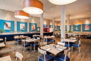 een restaurant met tafels en stoelen en blauwe muren bij Four Points by Sheraton Perth in Perth