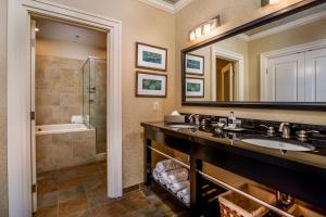 a bathroom with two sinks and a shower and a mirror at Craddock Terry Hotel, Lynchburg, a Tribute Portfolio Hotel in Lynchburg