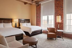 une chambre d'hôtel avec 2 lits et des chaises dans l'établissement Craddock Terry Hotel, Lynchburg, a Tribute Portfolio Hotel, à Lynchburg