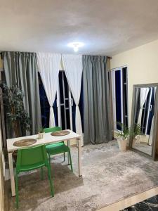 Cette chambre comprend une table, des chaises et des fenêtres. dans l'établissement Tiny Apartment By Merengue House, à Saint-Domingue