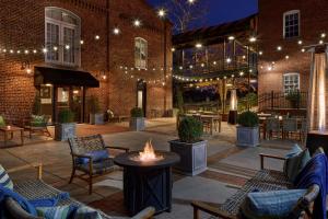 a patio with furniture and a fire pit in front of a building at Craddock Terry Hotel, Lynchburg, a Tribute Portfolio Hotel in Lynchburg