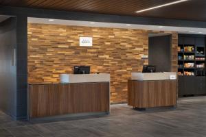 a lobby with two reception desks and a brick wall at Courtyard Portland East in Portland