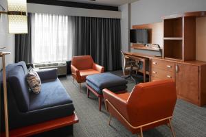 een hotelkamer met een bureau en stoelen en een woonkamer bij Courtyard by Marriott Charlottesville - University Medical Center in Charlottesville