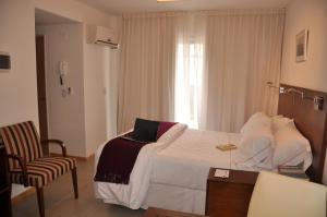 a hotel room with a bed with a laptop on it at Livin' Residence Rosario in Rosario