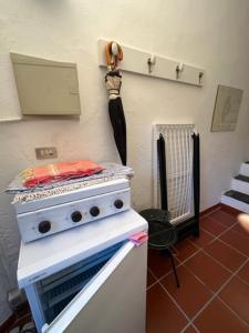 a kitchen with a stove and an umbrella hanging on the wall at Maison Des Amis in Capraia