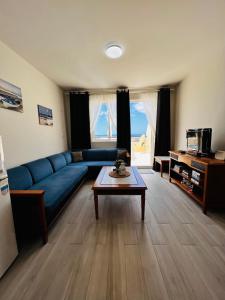 a living room with a blue couch and a table at Apartamento perla marina in Morro del Jable