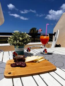 a wooden cutting board with food and a drink on a table at Apartamento perla marina in Morro del Jable