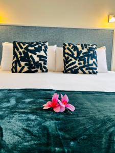 a pair of pink flowers sitting on a bed at Apartamento perla marina in Morro del Jable