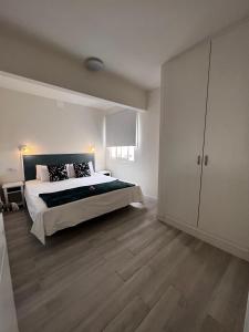 a large bedroom with a large bed and wooden floors at Apartamento perla marina in Morro del Jable