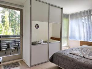 Moderní a slunný apartmán 2KK v Anenském Údolí se sklepem a parkováním - by Relax Harrachov في هاراشوف: غرفة نوم بسرير وخزانة زجاجية كبيرة