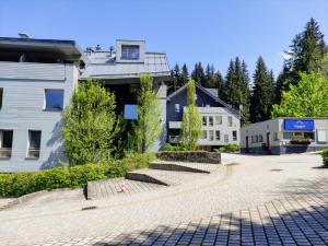 een geplaveide straat voor een gebouw bij Moderní a slunný apartmán 2KK v Anenském Údolí se sklepem a parkováním - by Relax Harrachov in Harrachov