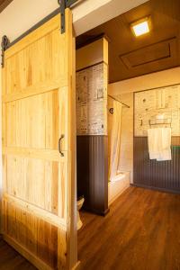 baño con puerta de madera y aseo en -Pet Friendly- Miners Cabin #6 - One Queen Bed with Private Balcony en Tombstone