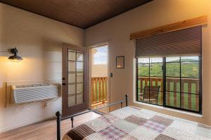 a bedroom with a bed and a balcony with a window at -Pet Friendly- Miners Cabin #6 - King Bed with Private Balcony in Tombstone