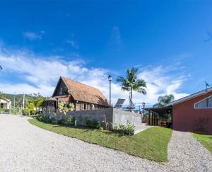 een huis met een stenen oprit naast een gebouw bij Pousada Gravatá in Gravatal