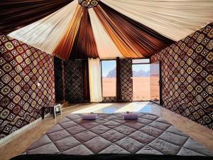 um quarto com uma cama grande num quarto com janelas em Salameh's Bedouin Camp em Wadi Rum