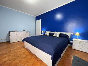 een blauwe slaapkamer met een bed en een blauwe muur bij Stefano's Guests House: 2 bedrooms & parking in Viareggio in Viareggio