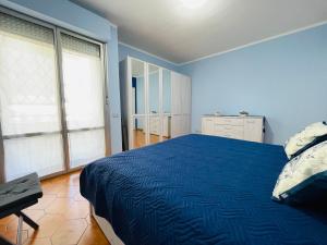 een blauwe slaapkamer met een bed en een bureau bij Stefano's Guests House: 2 bedrooms & parking in Viareggio in Viareggio