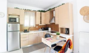 a kitchen with wooden cabinets and a white refrigerator at Παραθαλάσσια Βίλα in Neos Marmaras